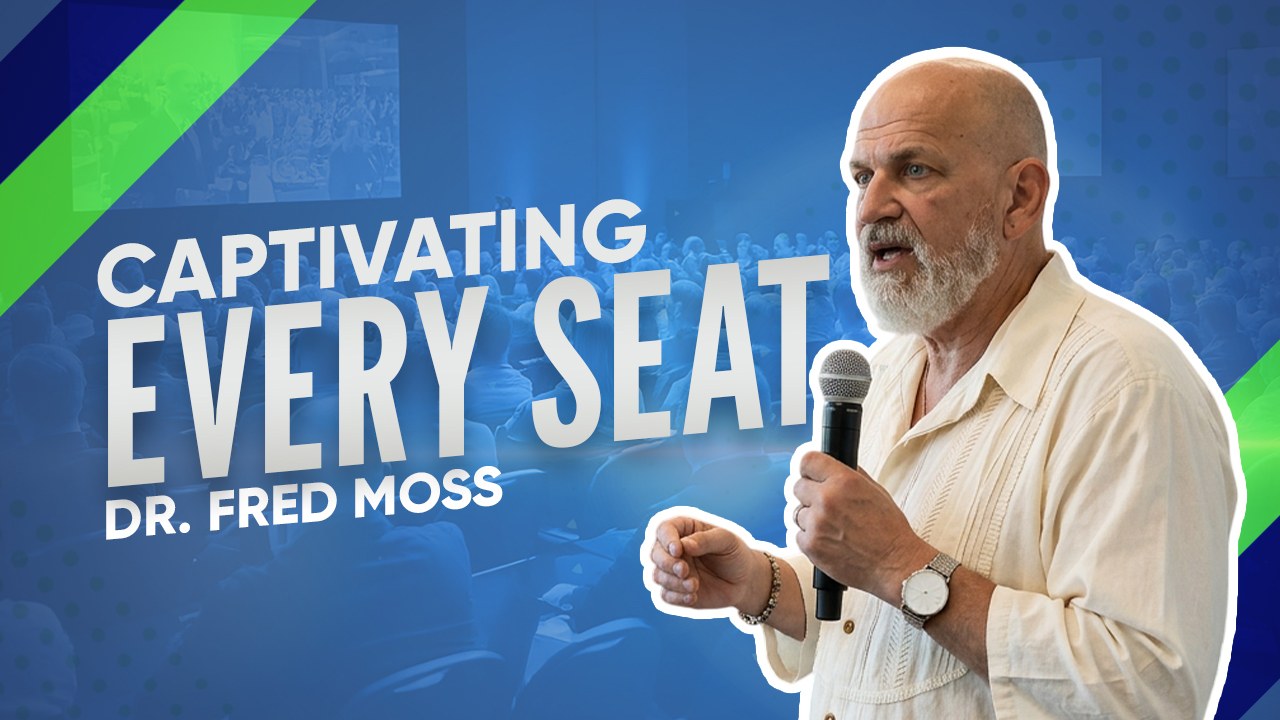 Dr. Fred Moss speaking on stage